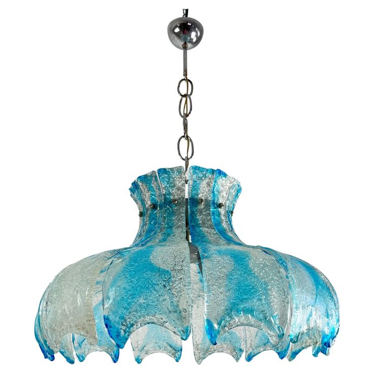 a blue glass chandelier hanging from a metal chain on an isolated white background