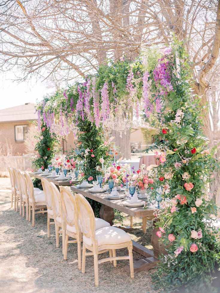 an outdoor dining area with flowers and greenery