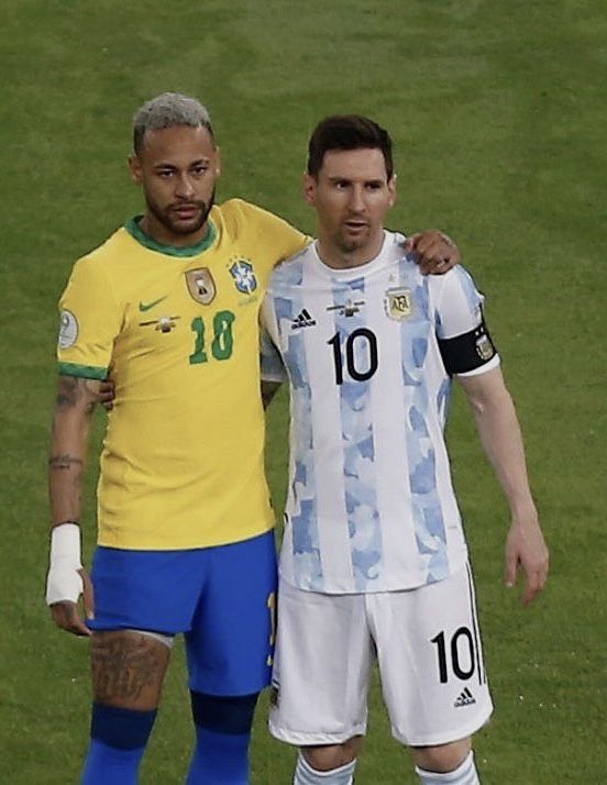 two men standing next to each other on a soccer field