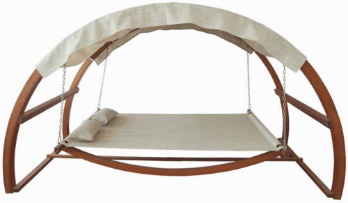 a wooden swing bed with white sheets on it