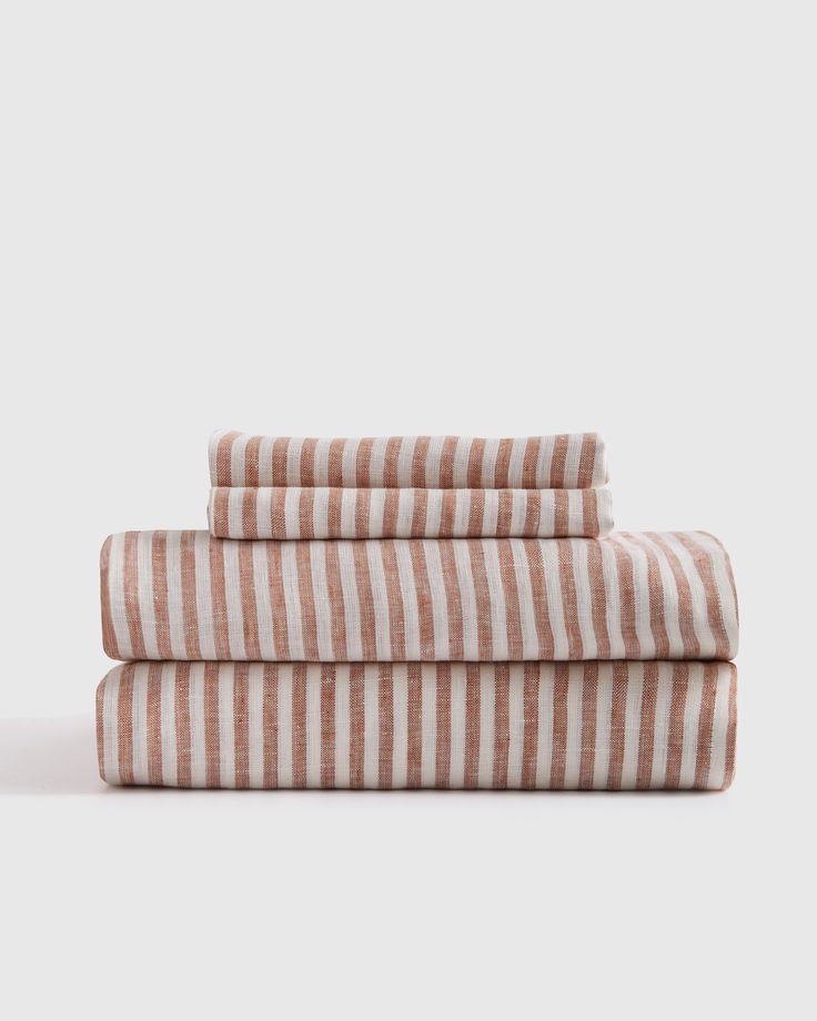 three striped sheets are stacked on top of each other, one is pink and white