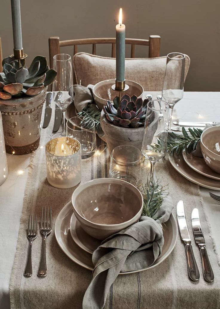 a table set for christmas with candles and plates