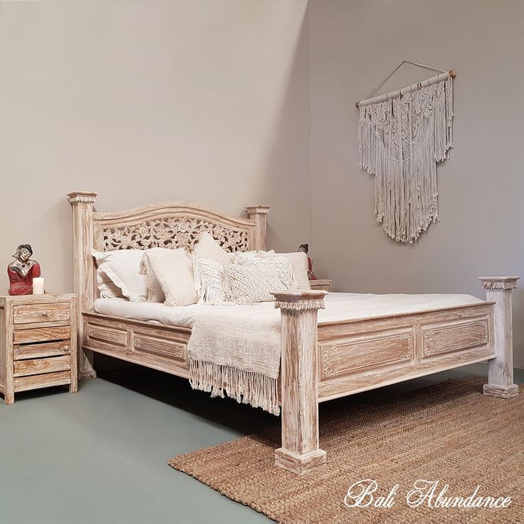 a white bed sitting next to a wooden dresser on top of a rug