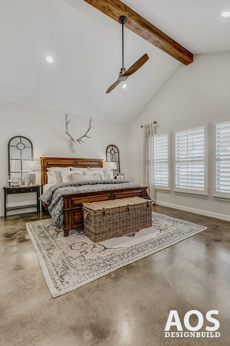 a bedroom with a bed, dresser and ceiling fan in the middle of the room