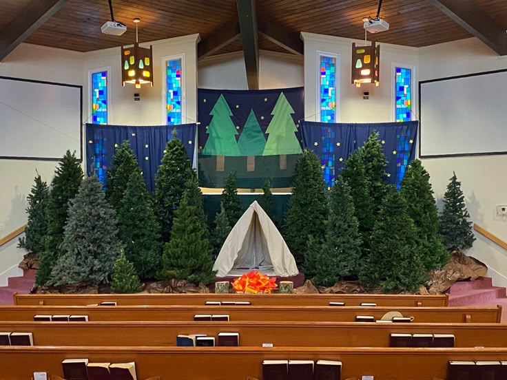 the interior of a church with rows of pews and decorated christmas trees on display