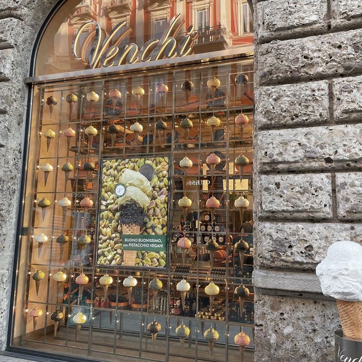 a store front with an assortment of nuts in the window and a stone wall behind it