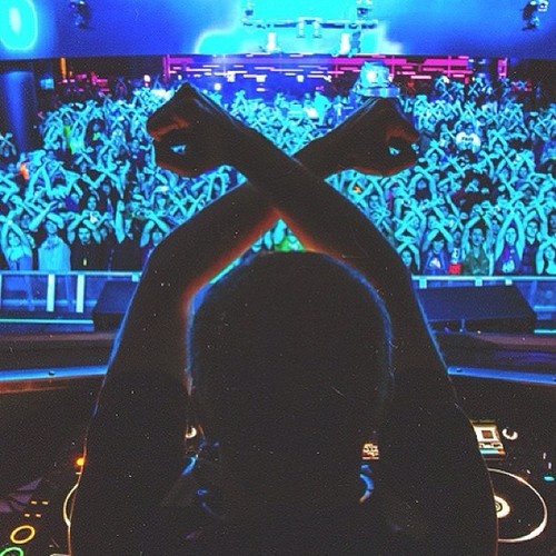 a person is sitting in front of a dj's turntable at a concert