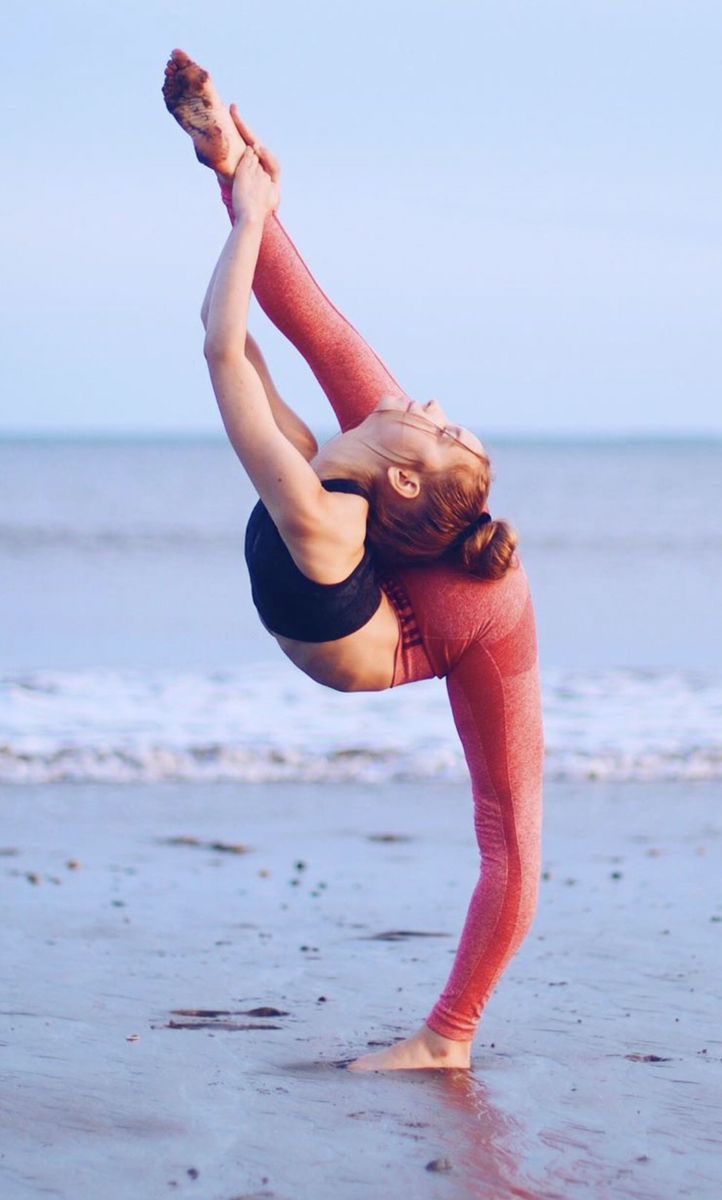 a woman is doing yoga on the beach