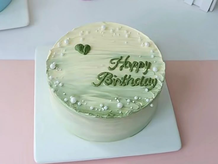 a birthday cake with the words happy birthday written in green frosting on top of it