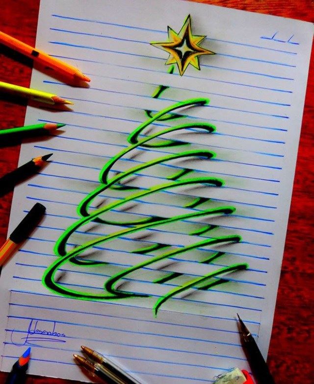 a christmas tree drawn on lined paper next to colored pencils and crayons