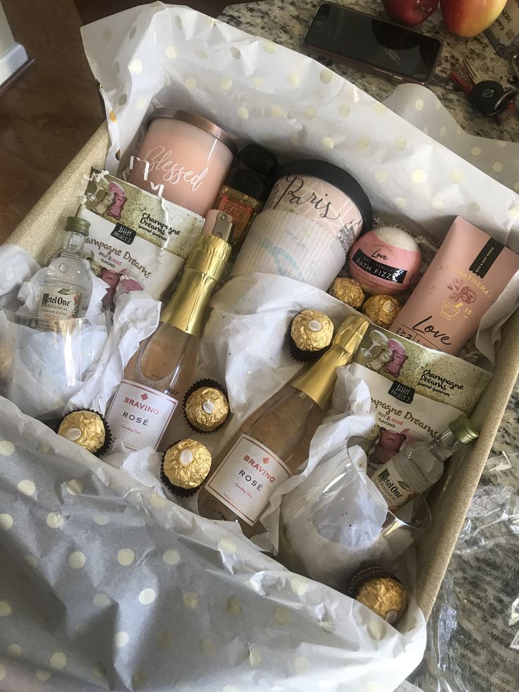 an open box filled with lots of different types of wine and chocolates on top of a table