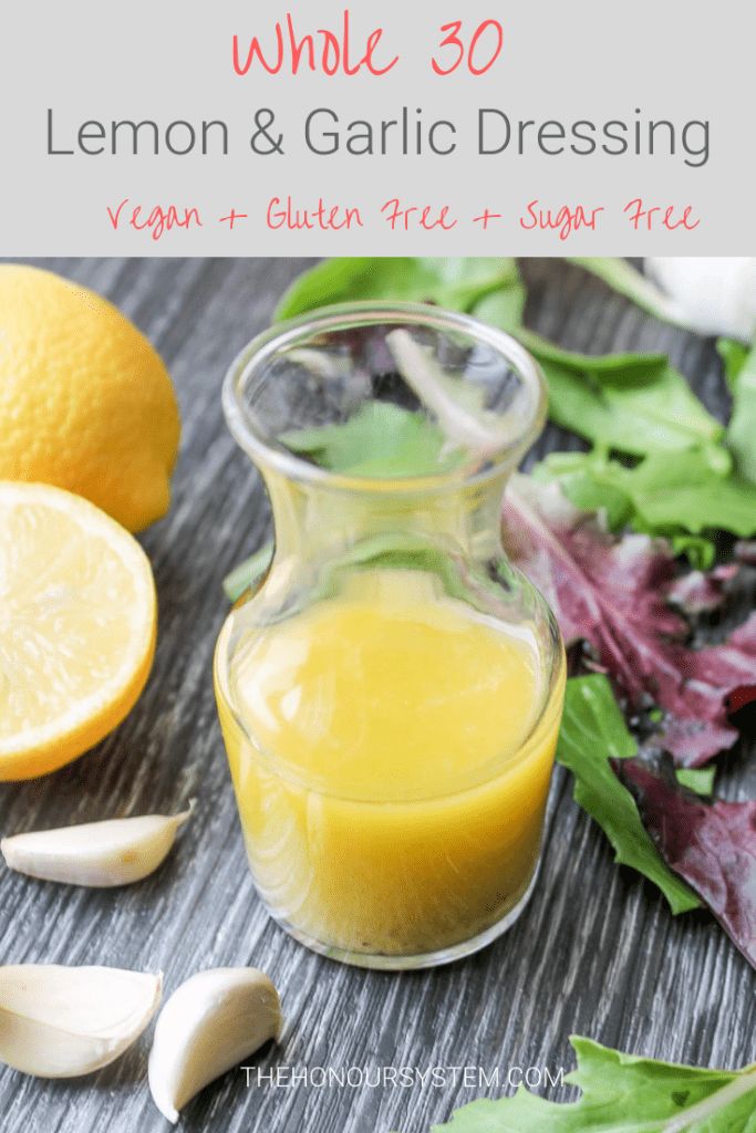 an assortment of vegetables and juice on a wooden table with garlic, lettuce, and lemon