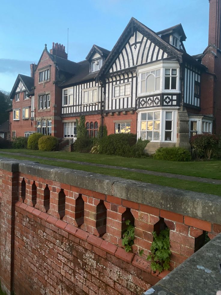 an old brick wall in front of a row of large buildings with windows and balconies