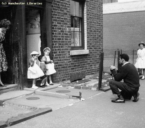 an old black and white photo of children playing baseball in front of a brick building