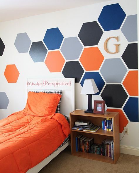 an orange and blue bedroom with hexagonal wallpaper