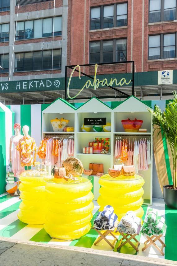 an outdoor store with giant yellow balloons in the foreground and other items on display