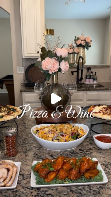 a table filled with different types of food and wine glasses on top of the counter