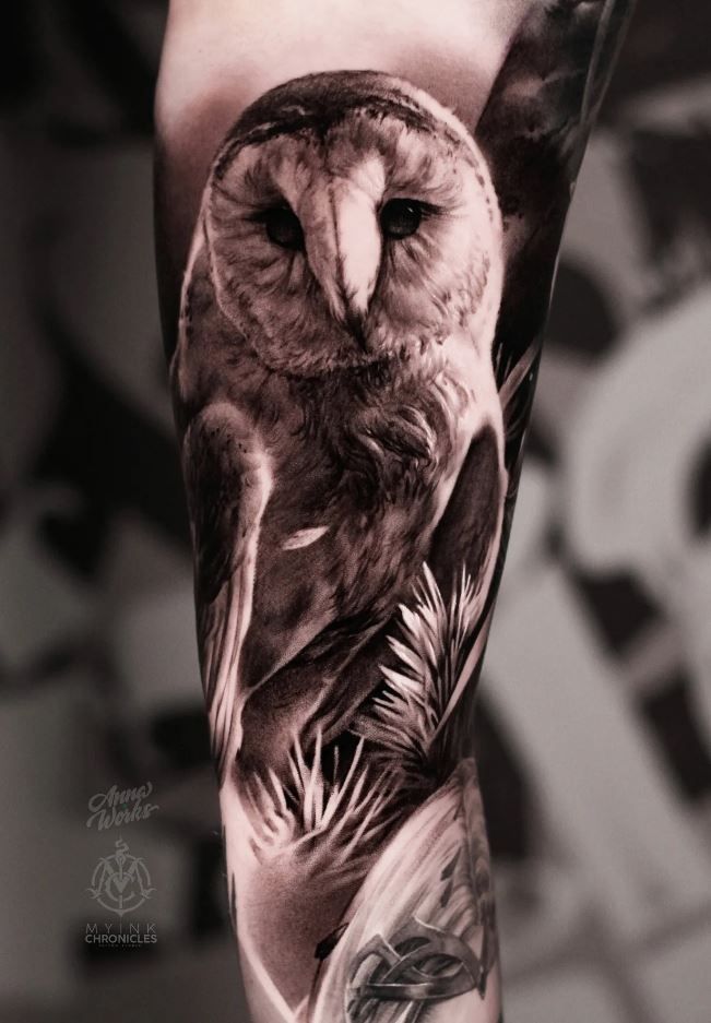 an owl tattoo is shown on the arm