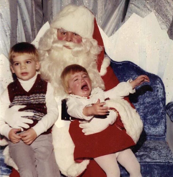 an old photo of santa claus and two children sitting on a blue chair with his mouth open