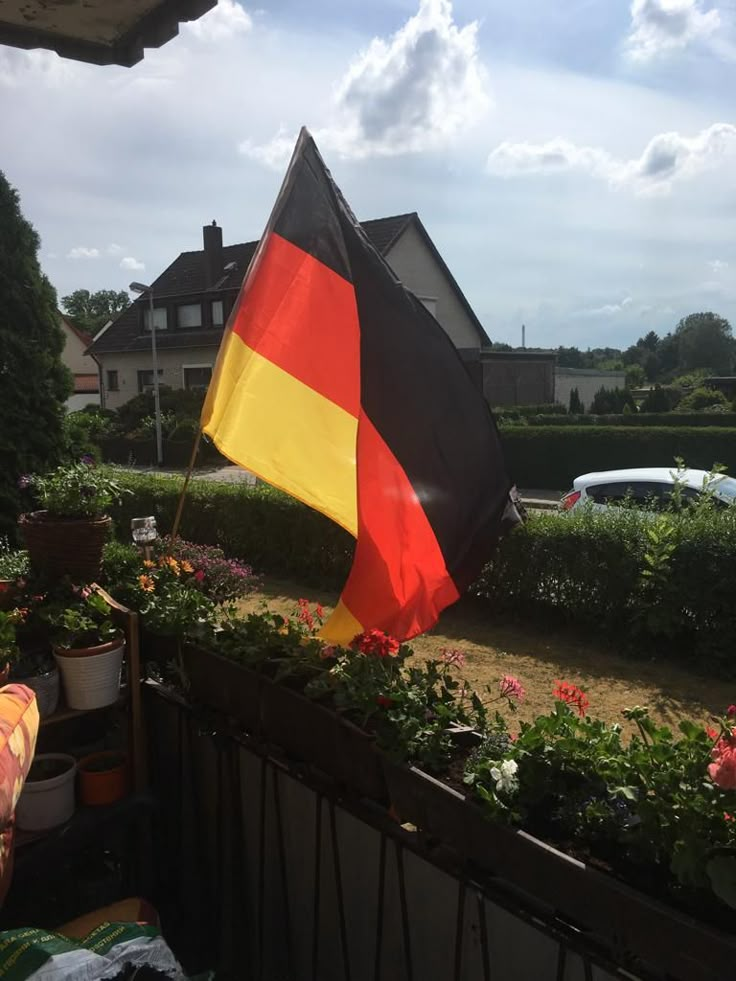 a german flag is in the middle of a flower garden