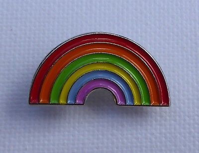 a rainbow brooch pin sitting on top of a white surface