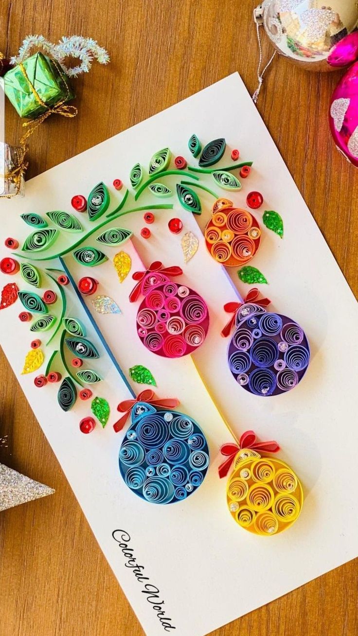 paper quilled ornaments are on top of a greeting card, next to other decorations