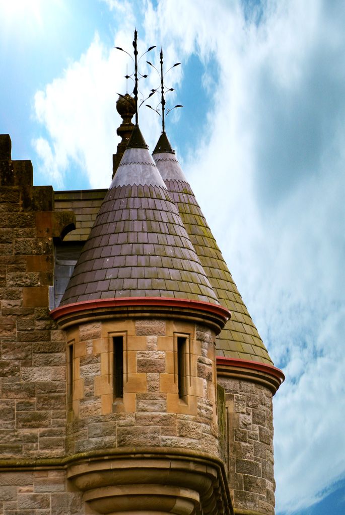 an old building with a clock on the top and a weather vane at the top