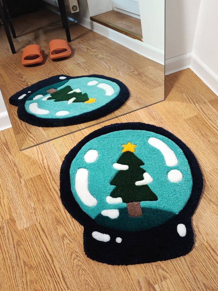 two rugs on the floor in front of a mirror with a christmas tree inside