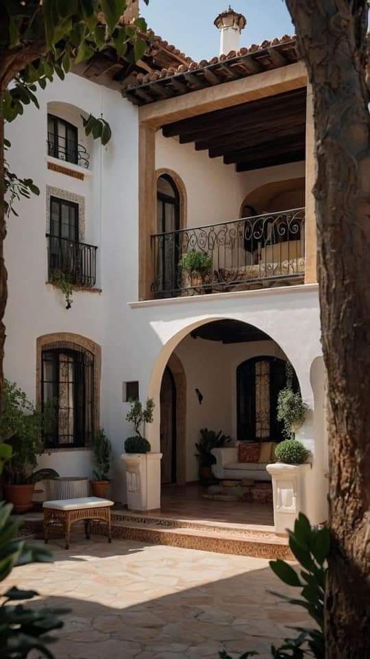 an outdoor patio with potted plants on the side and balconies above it