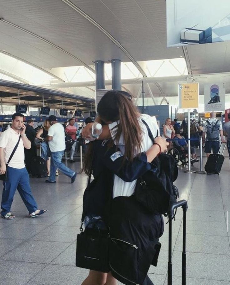 a woman is walking through an airport with her luggage