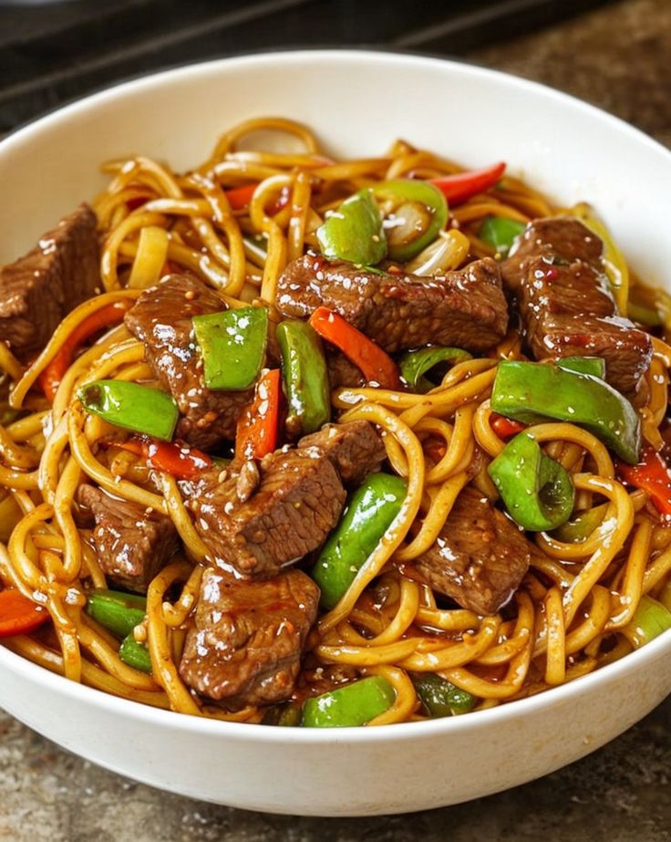 a white bowl filled with beef and noodles