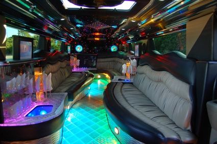 the inside of a party bus with lights and couches