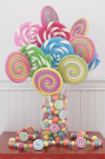 a vase filled with lots of colorful lollipops on top of a table