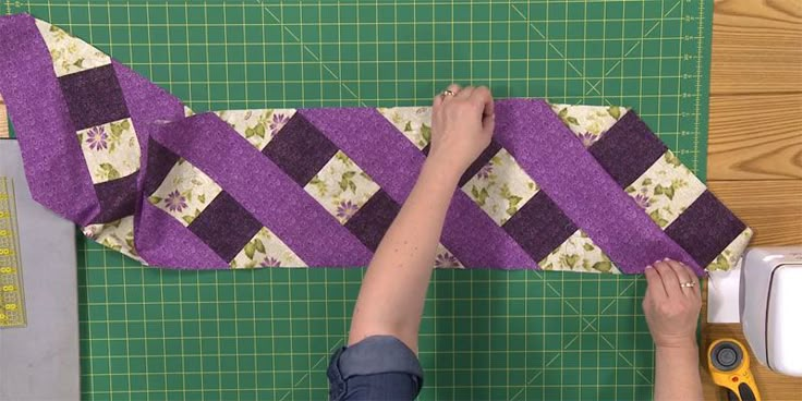 a woman is working on a piece of fabric