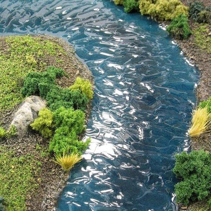 a small river running through a lush green forest