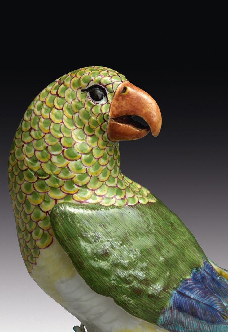 a green bird statue sitting on top of a table