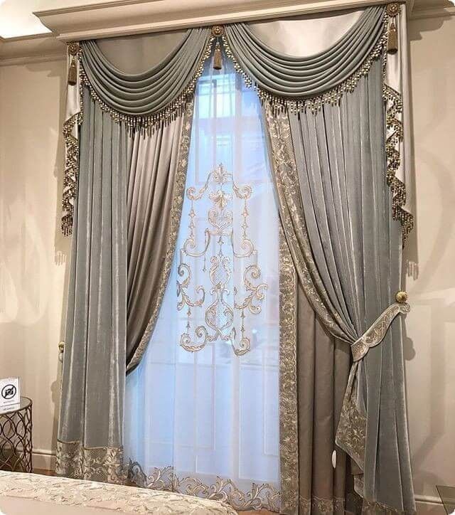 the curtains are hanging in front of the window with draperies on it and an ornate chandelier