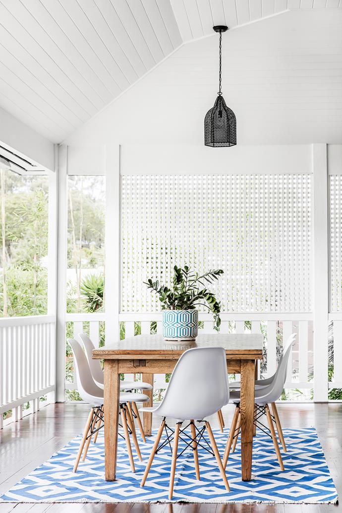 a dining room table with chairs and a rug on the floor