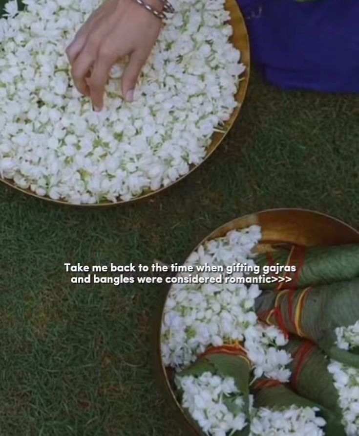 two bowls filled with white flowers on top of grass