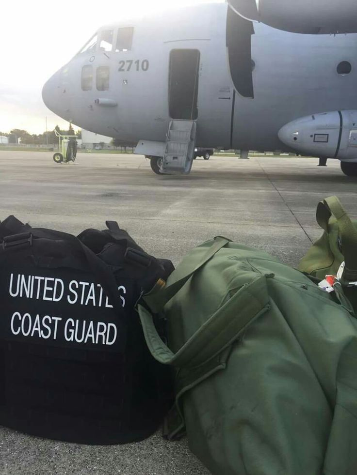 two bags sitting on the ground next to an airplane