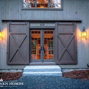 a barn with two doors and lights on the side