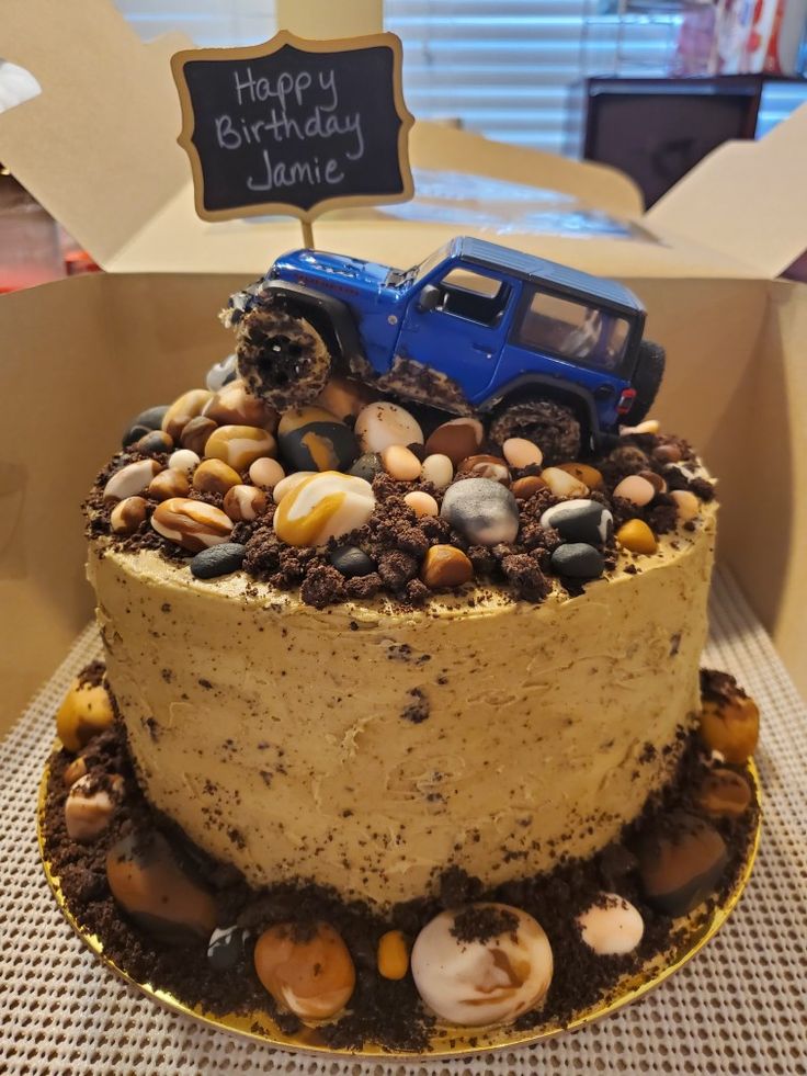 a birthday cake decorated with rocks and a toy truck