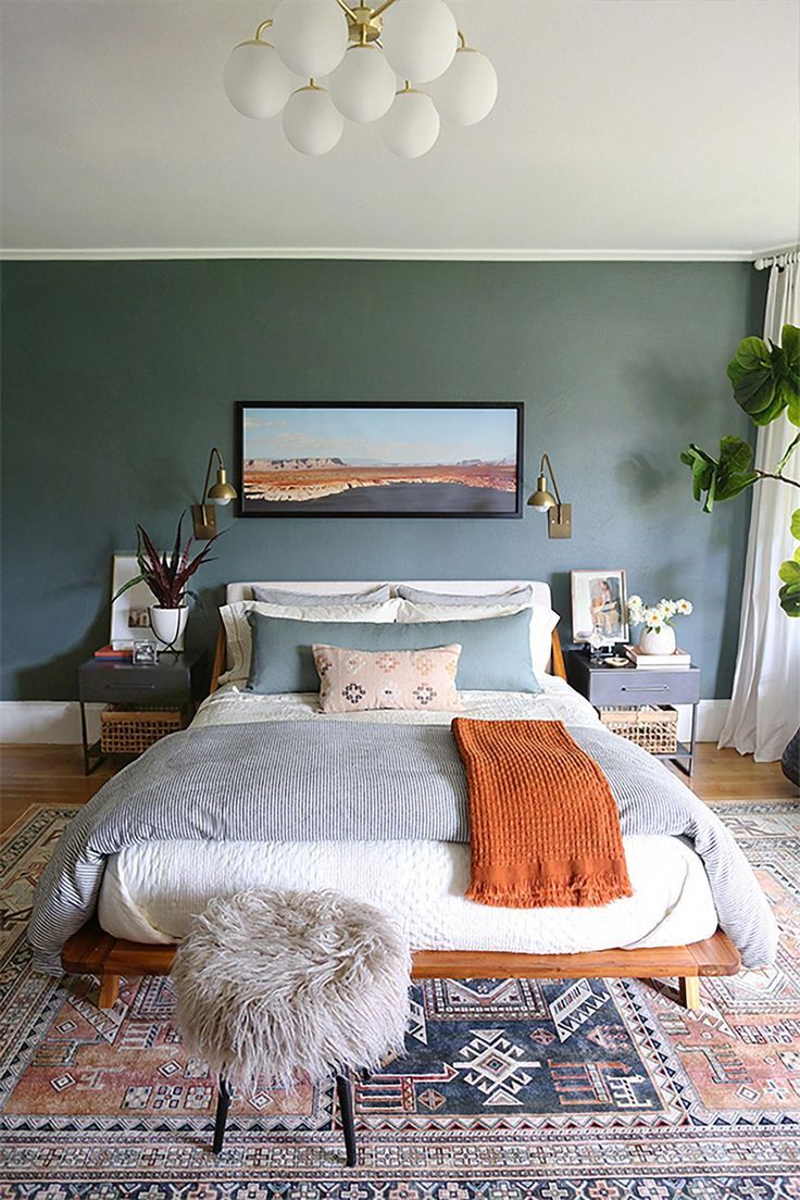 a bedroom with a large bed and rugs on the floor in front of it