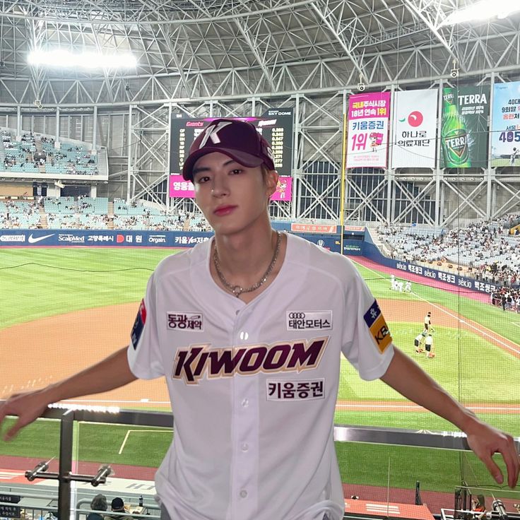 a baseball player standing in front of the stands at a stadium with his hands on his hips