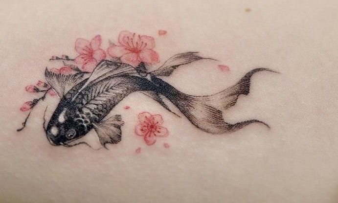 a woman's back with a fish and flowers on it