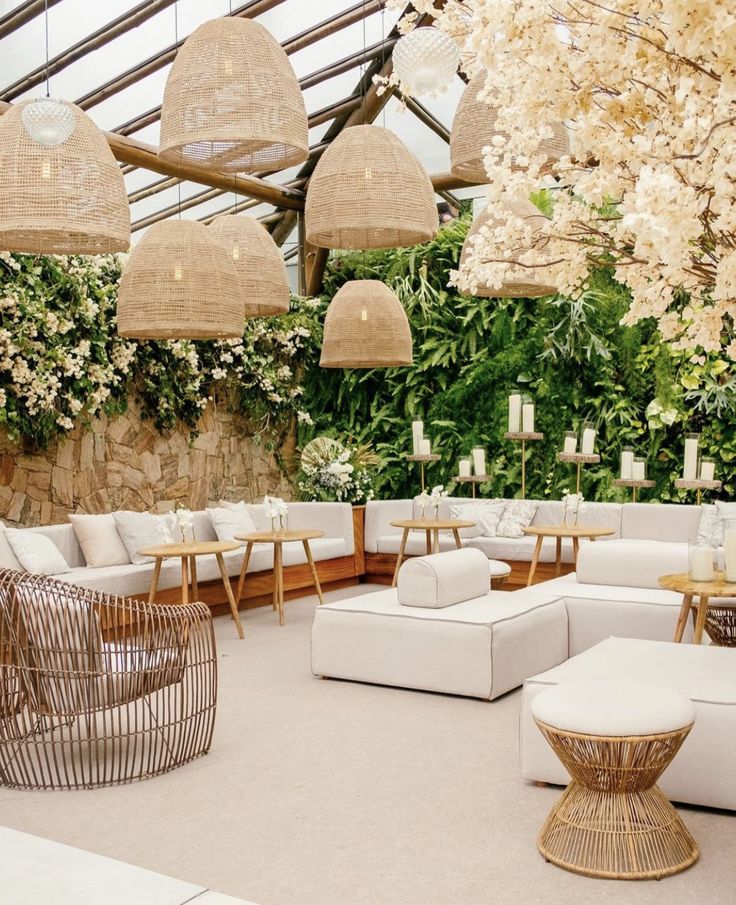 a living room filled with lots of white furniture and flowers on the wall behind it