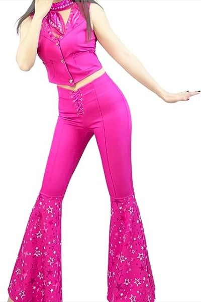 a woman in a pink outfit is holding her hands out to the side and she has one hand on her hip