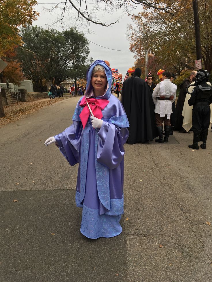 a woman dressed in costume walking down the street