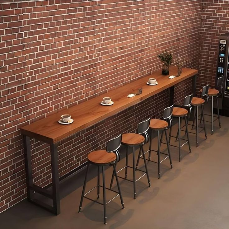 a row of bar stools next to a brick wall with a vending machine