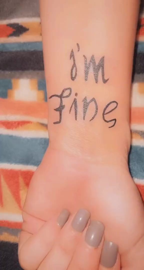 someone has written the words i'm fine on their left arm and hand, which is covered in black ink